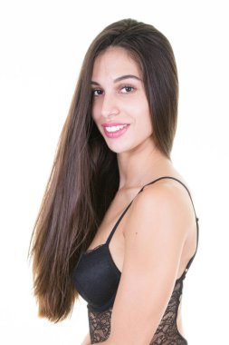 Beyaz stüdyoda şık iç çamaşırlarıyla poz veren çekici, genç, esmer kadın.