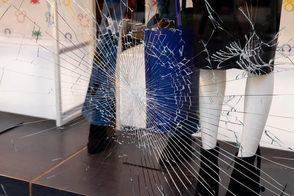 Shattered window of broken storefront store crack from impact on shop glass boutique
