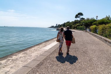 Çiftler yaz günü Fransa 'nın La Rochelle şehrinde sahil kenarında tatil yapıyorlar.