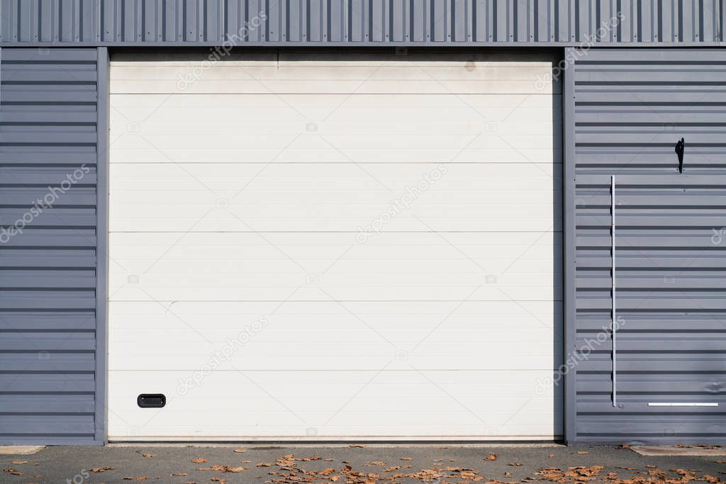 Industrial gray Unit facade of storehouse with closed white metal gate door