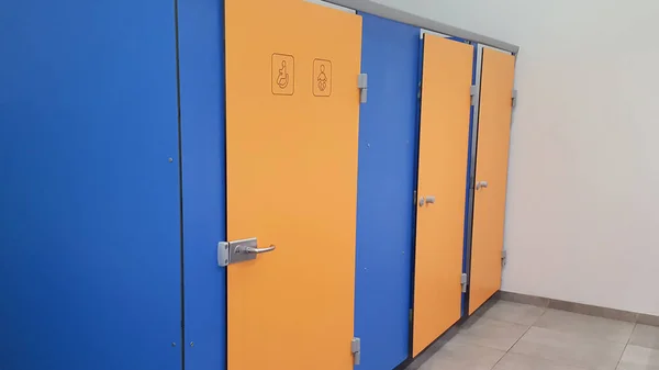 Empty door public toilet interior blue yellow color