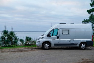 Kamp karavanı kışın deniz kenarına park etmiş. Vanlife Day in French Coast in Capret Village France.