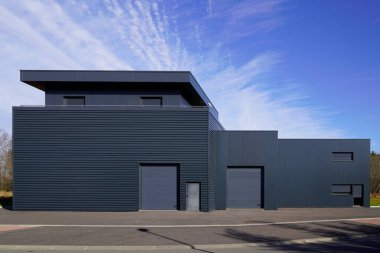 Gri büyük sanayi binası dış depo gri hangar dış kapılar mavi gökyüzünde