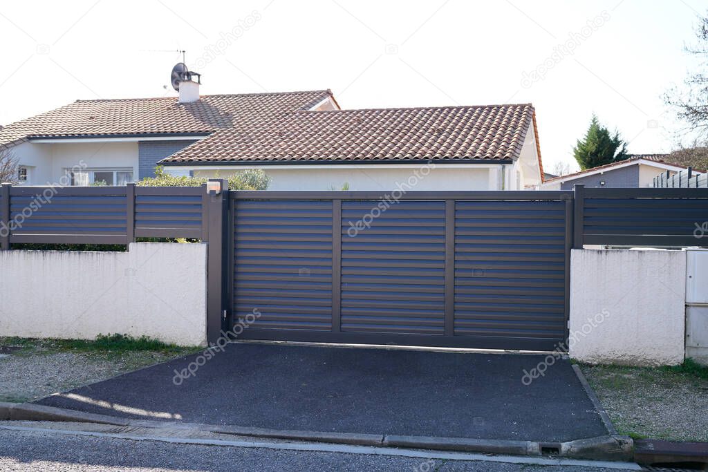 large metal gate grey fence on suburb street house