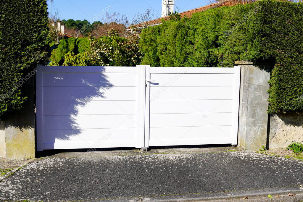 large metal gate white fence on home suburb street access house garden