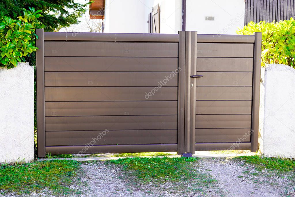 Metal brown driveway entrance gates house access garage in suburb