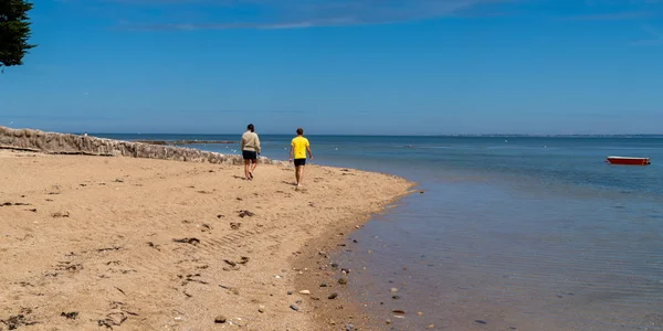 tourist couple walking in sandy sea beach in Atlantic ocean in Ile de Noirmoutier France