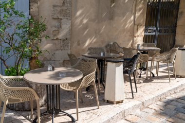 Avignon France 'ta açık bir kafe terasında boş retro masalar ve sandalyeler.