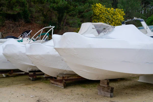power boat parking covered white protective plastic film new modern boats in cover casing shrink wrap on sailboat stored for season cold winter