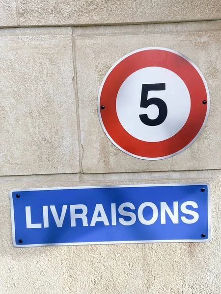 French sign livraisons means deliveries and Road sign to limit the speed to 5 km / h