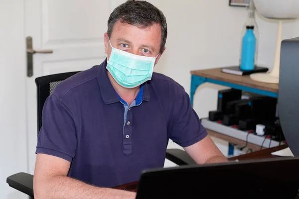 Man with coronavirus mask working at home office disease covid-19