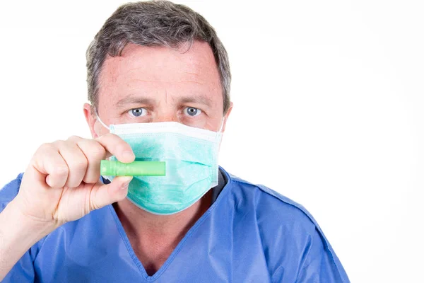 男医生药剂师手戴防护手套蓝色口罩举行绿色验尸管测试 — 图库照片
