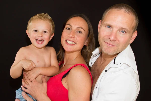 Glückliche Dreiköpfige Familie Steht Auf Schwarzem Hintergrund — Stockfoto