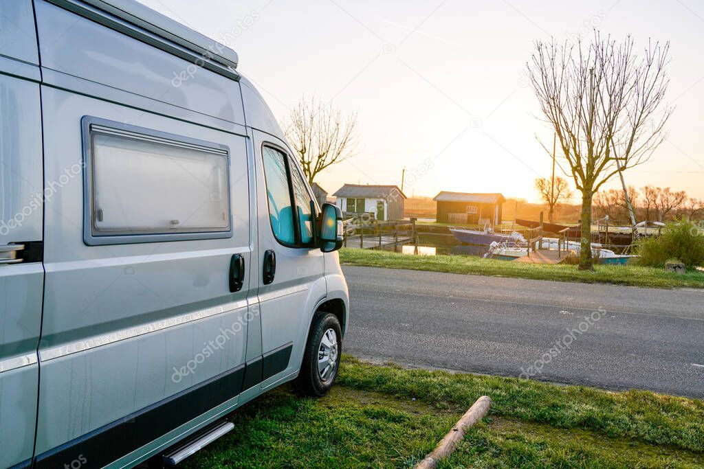 Camper van park for night motor home vacation rv at sunset