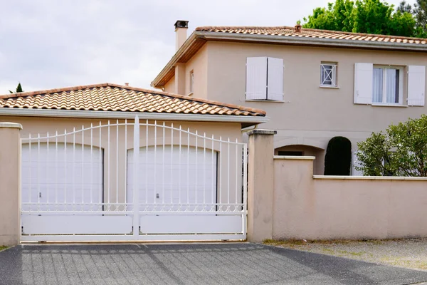 white metal house gate with double garage