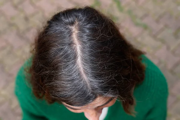 Woman first appearance of gray hair roots