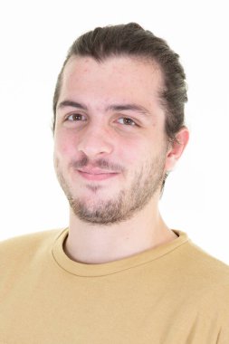 Genç, uzun saçlı, sakallı, saçları bağlı, gülümseyen bir adam.