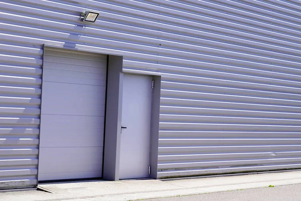 垂直プロファイルシート上の灰色の金属ロールダウンシャッター商業産業ユニットの灰色の建物の火災出口ドア — ストック写真