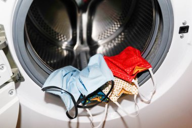 Coronavirus 'u temizlemek için çamaşır makinesinde ev yapımı birkaç maske.