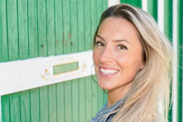 美しい笑顔かわいいです女性上の木のトレンディーな緑の壁小屋の背景 — ストック写真