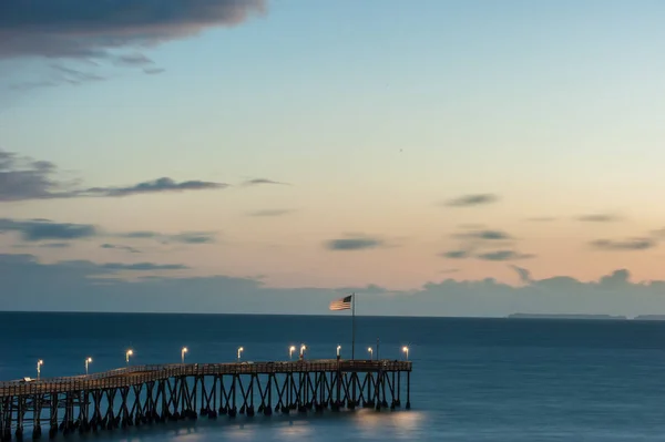 Cielo resplandeciente y bandera ondeante a lo largo del muelle Ventura . —  Fotos de Stock