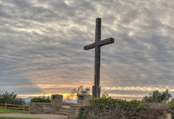 Majestic sunrise behind Christian monument of faith.