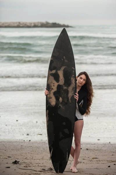 Surfista bonita escondida atrás da prancha . — Fotografia de Stock