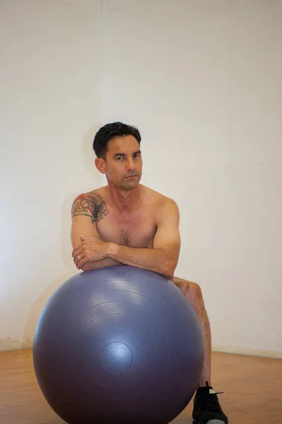 Shirtless man posing on balance ball. — Stock Photo, Image