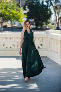 Alternatif sarışın model ile dengeli ve güven zümrüt yeşil resmi cüppe beton pist aşağı yürüme.