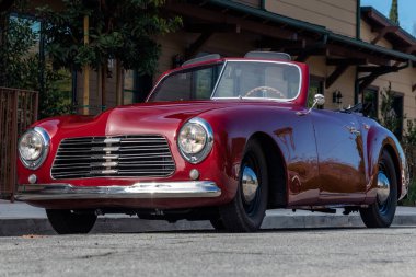 Klasik 1951 Simca 8 spor üstü açık araba güneşli bir günde çatısı açık, 3 / 4 önden güzel görünüyor..