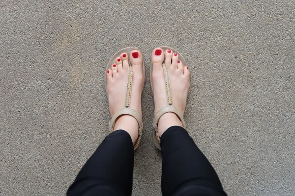 Pies femeninos con zapatillas o chanclas al aire libre clavo rojo — Foto de Stock