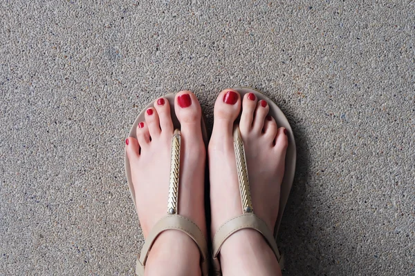 Pés femininos usando chinelos ou flip-flop unhas vermelhas ao ar livre — Fotografia de Stock