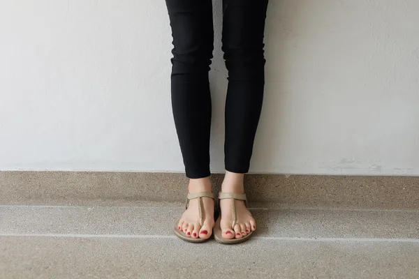 Pés femininos usando chinelos ou flip-flop unhas vermelhas ao ar livre — Fotografia de Stock