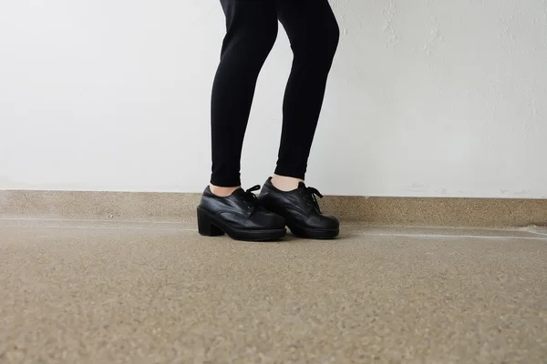 Gambe femminili in scarpe di moda. Concetto di scarpe nere moda all'aperto sul pavimento — Foto Stock