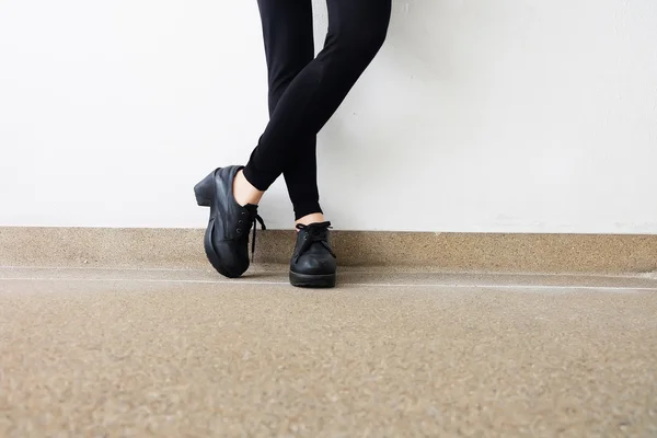 Piernas femeninas en zapatos de moda. Concepto de zapatos negros de moda al aire libre en piso —  Fotos de Stock