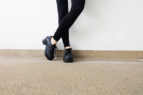 Frauenbeine in Modeschuhen. Outdoor-Mode schwarze Schuhe Konzept auf dem Boden — Stockfoto