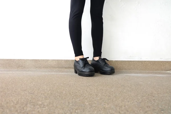 Piernas femeninas en zapatos de moda. Concepto de zapatos negros de moda al aire libre en piso —  Fotos de Stock