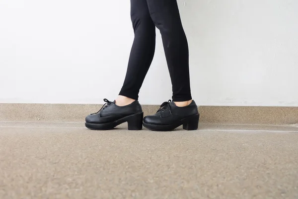 Pernas Femininas em Sapatos de Moda. Moda ao ar livre preto sapatos conceito no chão — Fotografia de Stock