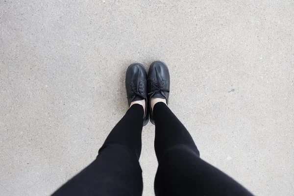 Frauenbeine in Modeschuhen. Outdoor-Mode schwarze Schuhe Konzept auf dem Boden — Stockfoto