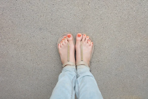 Gouden schoenen (slippers) op meisje benen en voeten op de grond — Stockfoto