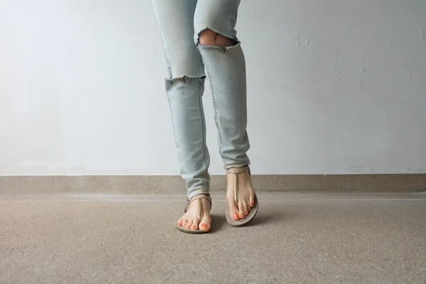Gouden schoenen (slippers) op meisje benen en voeten op de grond — Stockfoto