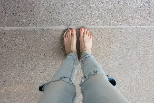 Chaussures en or (pantoufles) sur les jambes et les pieds des filles au sol — Photo