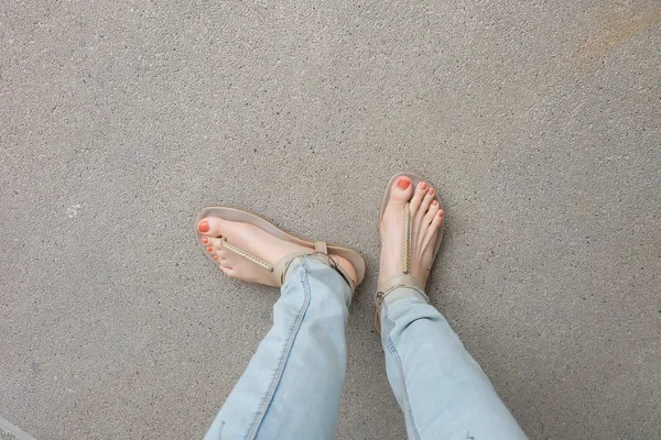 Sapatos de ouro (chinelos) em pernas e pés de menina no chão — Fotografia de Stock