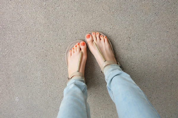 Sapatos de ouro (chinelos) em pernas e pés de menina no chão — Fotografia de Stock