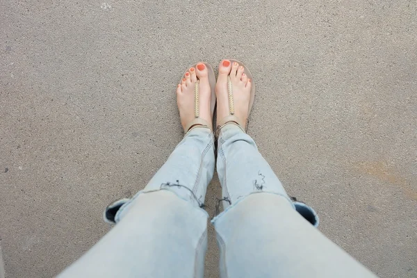 Gouden schoenen (slippers) op meisje benen en voeten op de grond — Stockfoto