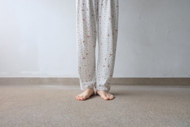 Zemin veya zemin arka planda bitki ile genç kadın ayakları 