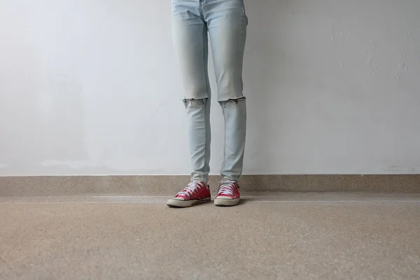 Fiatal Fashion Női lábak Blue Jeans és a Red cipők a floor — Stock Fotó