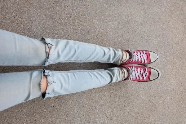 Young Fashion Woman's Legs in Blue Jeans and Red Sneakers on Floor — Stock Photo, Image