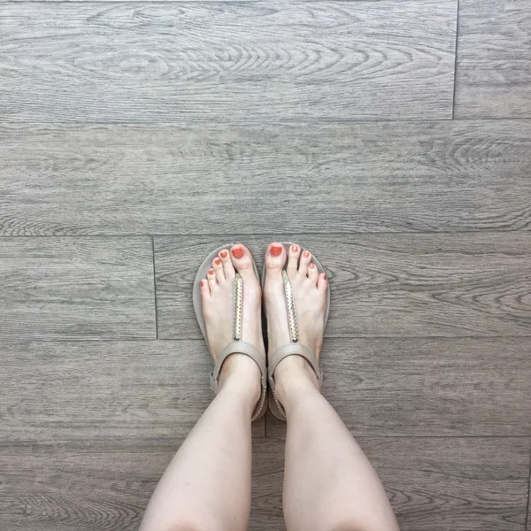 Pie femenino en sandalias sobre fondo de tierra — Foto de Stock