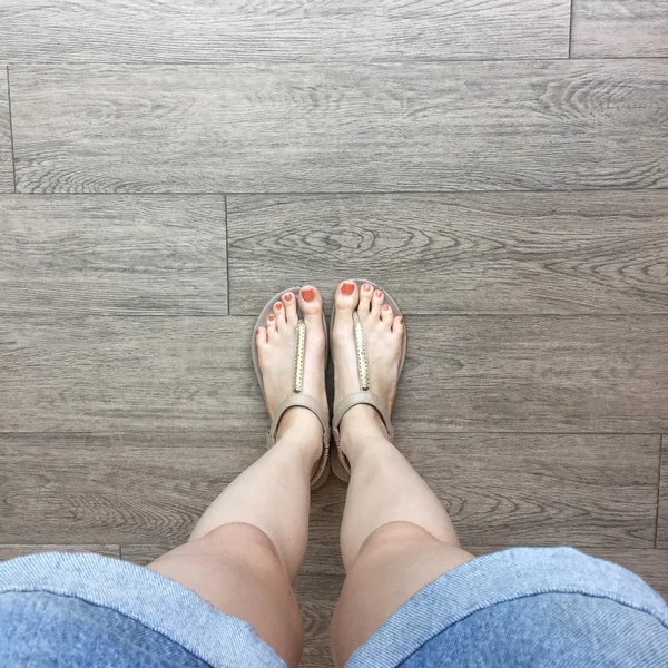 Kvinnlig fot i sandaler på Ground bakgrund — Stockfoto